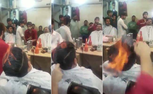 Watch Pakistani barber literally sets client's hair on fire to give scary haircut