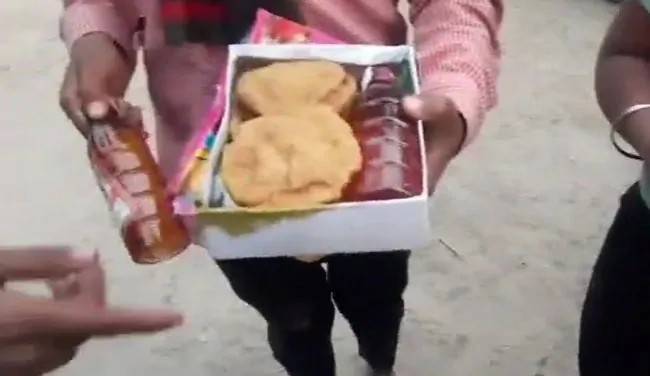 BJP leader in hot waters for distributing liquor outside Indian temple (VIDEO)