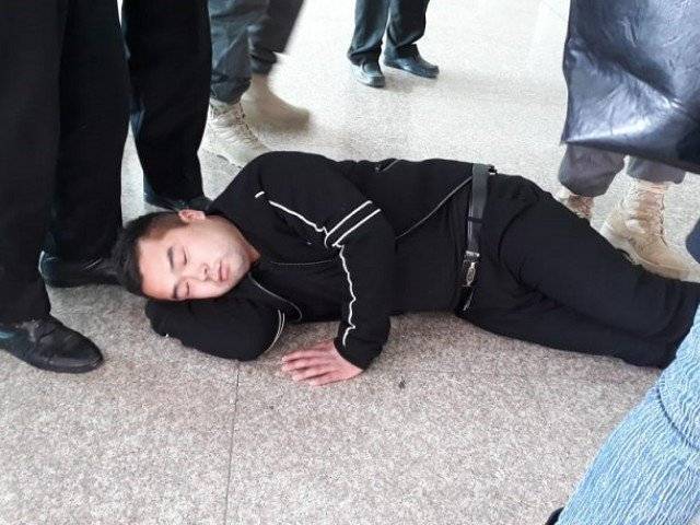 Chinese passengers protest against mobile phone custom duty by lying on floor at Islamabad airport