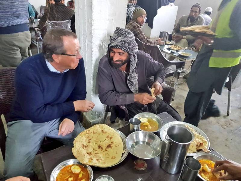 German envoy Martin Kobler shares a meal with homeless people