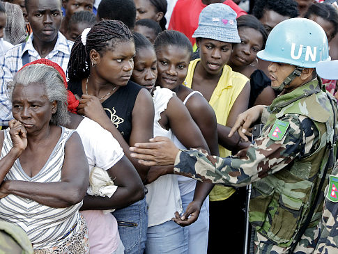 U.N. peacekeepers, from Nepal, help to organized the lines of earthquake survivors during a food distribution in Petionville, Haiti, Monday, Feb. 1, 2010. A 7.0-magnitude earthquake hit Haiti on Jan. 12 leaving thousands dead and many displaced. (AP Photo/Andres Leighton) Original Filename: Haiti_Earthquake_PAP138.jpg
