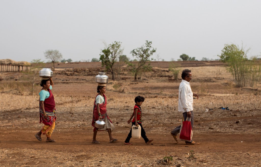 Bhaagi (L) and Sakhri (2nd from L), wives of Sakharam Bhagat (R) walk to fetch water from a well outside Denganmal village, Maharashtra, India, April 20, 2015. In Denganmal, a village in Maharashtra state, some men take a second or third wife just to make sure their households have enough drinking water. Becoming what are known as 