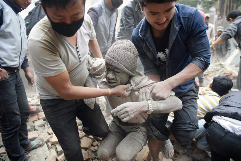 epa04719890 People free a man from the rubble of a destroyed building after an earthquake hit Nepal, in Kathmandu, Nepal, 25 April 2015. A 7.9-magnitude earthquake rocked Nepal destroying buildings in Kathmandu and surrounding areas, with unconfirmed rumours of casualties. The epicentre was 80 kilometres north-west of Kathmandu, United States Geological Survey. Strong tremors were also felt in large areas of northern and eastern India and Bangladesh. EPA/NARENDRA SHRESTHA EPA/NARENDRA SHRESTHA