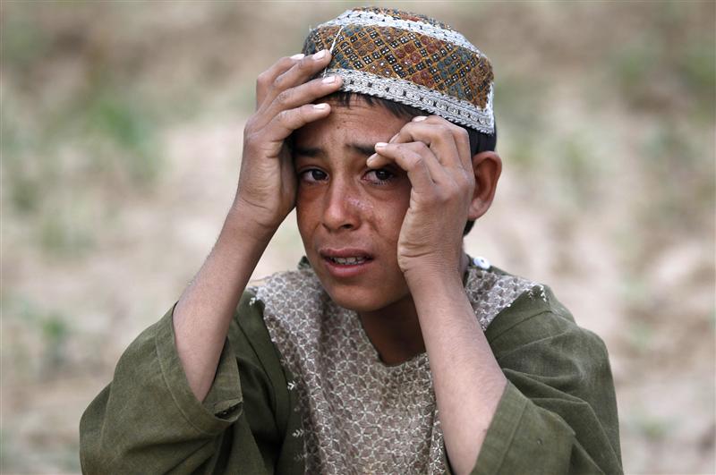 A boy weeps after a man who US Army soldiers said fired on them with an AK-47 was shot and killed near the village of Samir Kalacheh in Arghandab Valley north of Kandahar July 28, 2010. Soldiers said they saw three men shooting at them and returned fire, killing one man and injuring another. REUTERS/Bob Strong (AFGHANISTAN - Tags: CONFLICT MILITARY)