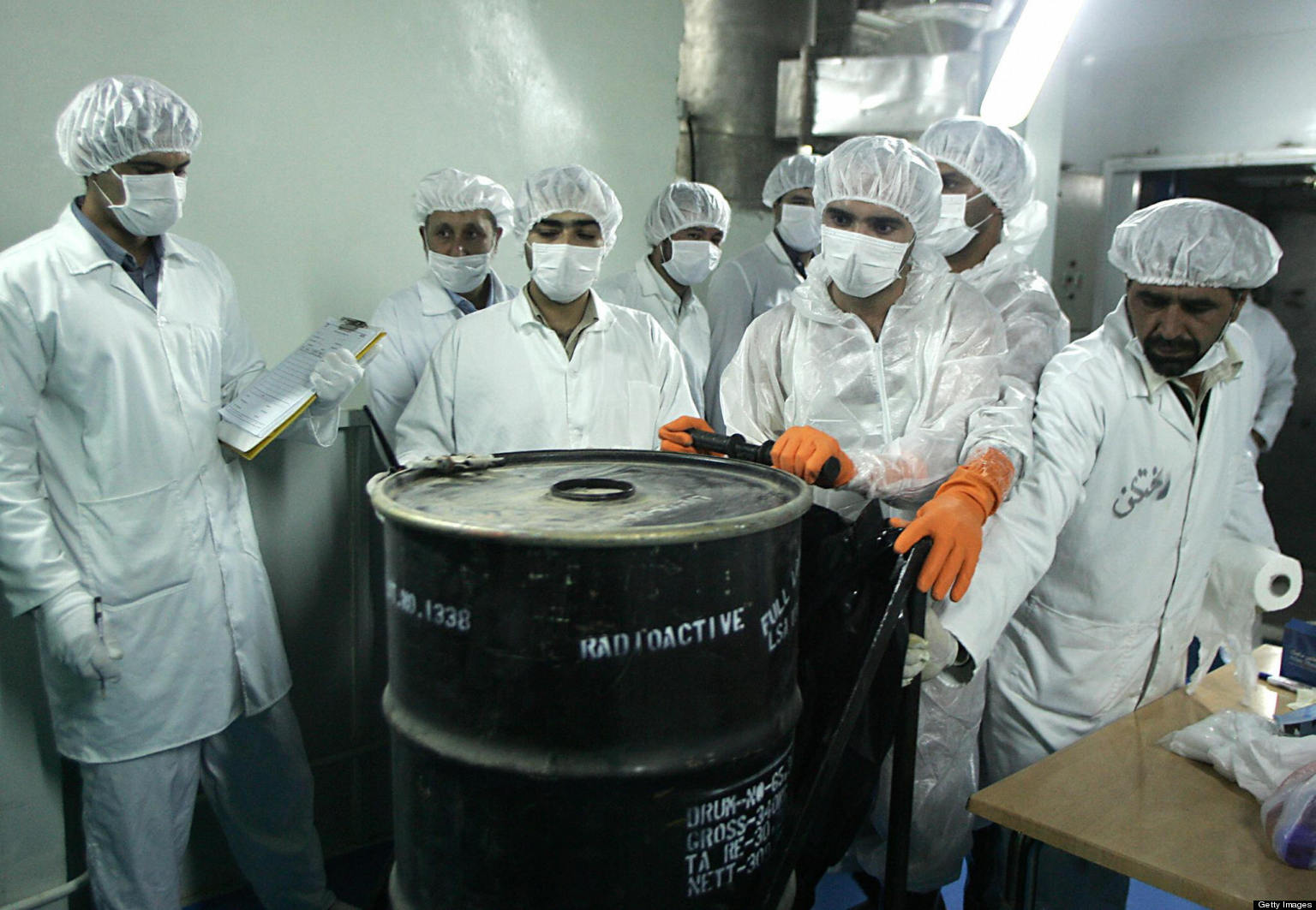 ISFAHAN, IRAN: Iranian technicians remove a container of radioactive uranium, 'yellow cake', sealed by the International Atomic Energy Agency, to be used at the Isfahan Uranium Conversion Facilities (UCF), 420 kms south of Tehran, 08 August 2005. Iran looked set to resume sensitive nuclear fuel work imminently after the arrival of UN inspectors at a uranium conversion plant, a move that would put it on a collision course with the West. AFP PHOTO/BEHROUZ MEHRI (Photo credit should read BEHROUZ MEHRI/AFP/Getty Images)