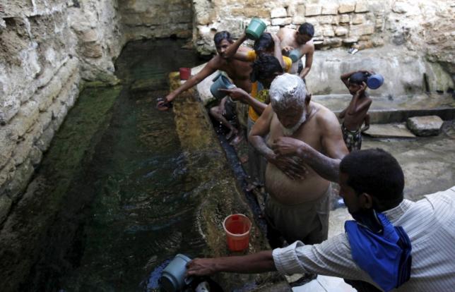 People bathe with spring water at the shrine of Hasan-al-Maroof Sultan Manghopir, better known as the crocodile shrine, on the outskirts of Karachi, Pakistan October 11, 2015. REUTERS/Akhtar Soomro