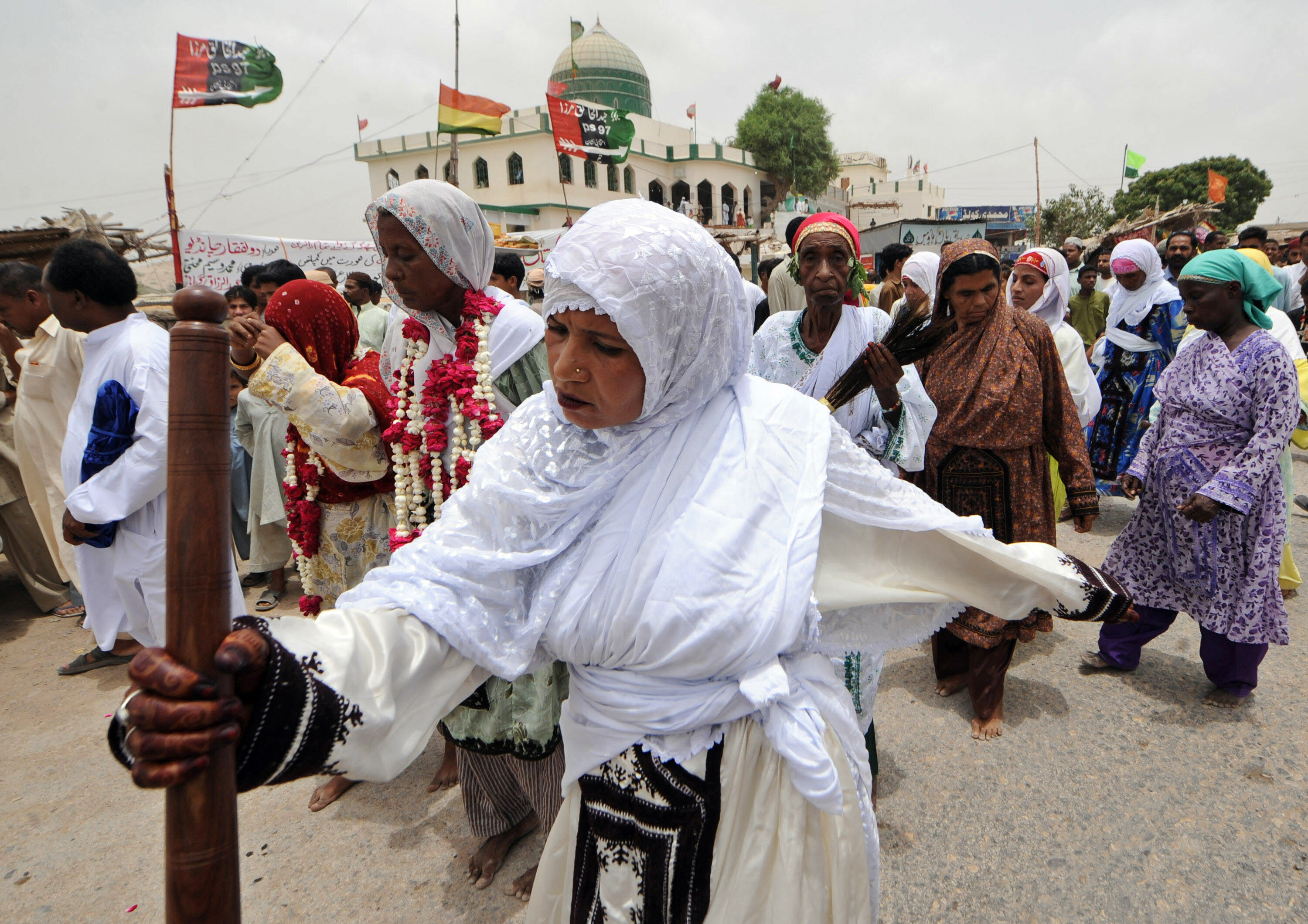 Pakistani devotees dance on the third day of the Sheedi festival at The Manghopir Shrine on the outskirts of Karachi on July 6, 2008. The Sheedi festival, named after the inhabitants of the area, is held near Saint Kwaja Hasan's shrine which is said to be the oldest Sufi shrine in the city. Sheedis, a lower class community in the city, follow the legend which says that saints found redemption here and during the festival feed the sacred crocodiles, beat drums and other musical instruments and sing songs. AFP PHOTO/ Asif HASSAN