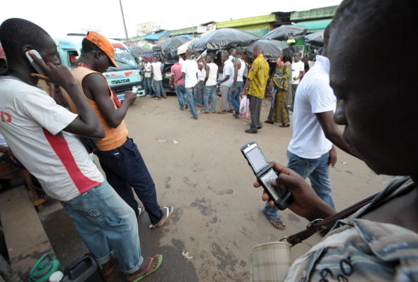 Men speak on mobile phones at the Adjame market in Abidjan on June 23, 2009. The African market for mobile telephones has since 2002 shown the 