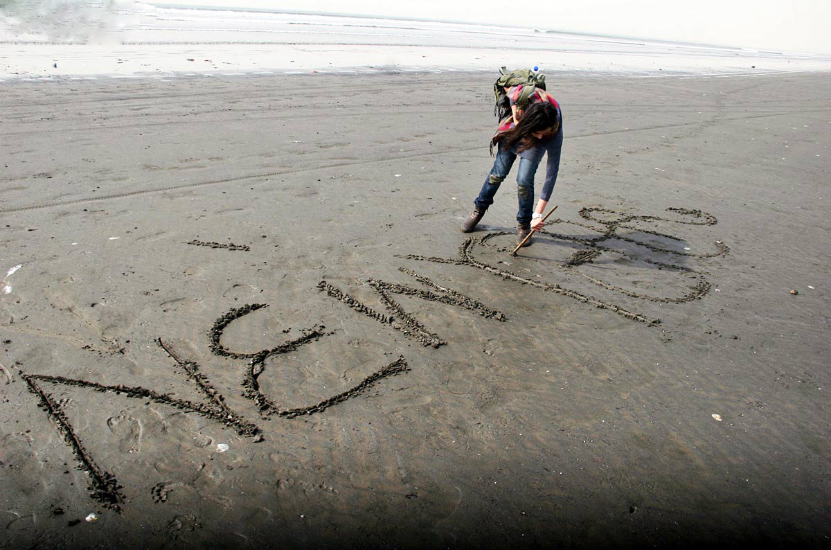 Girls write ‘New Year’ on sand at sea view in Karachi.–Online