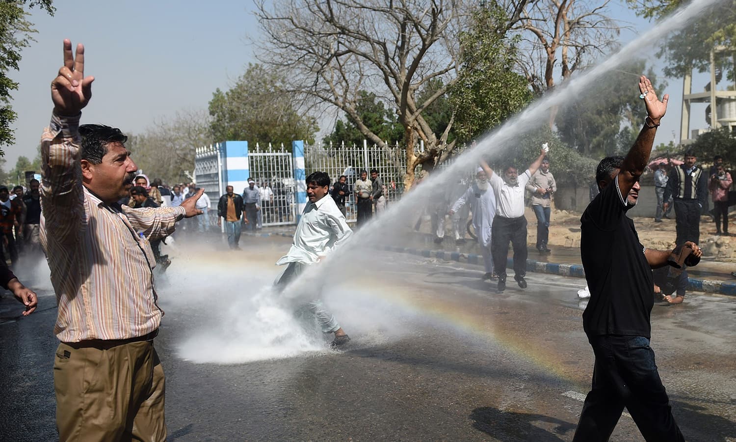 Pakistani employees of Pakistan International Airlines (PIA) shout slogans as police use a water cannon on them during a protest near Karachi International Airport in Karachi on February 2, 2016. Two demonstrators were shot dead and several more were wounded at Karachi's international airport when clashes broke out between security forces and staff from the national airline protesting privatisation plans, officials said. AFP PHOTO / RIZWAN TABASSUM