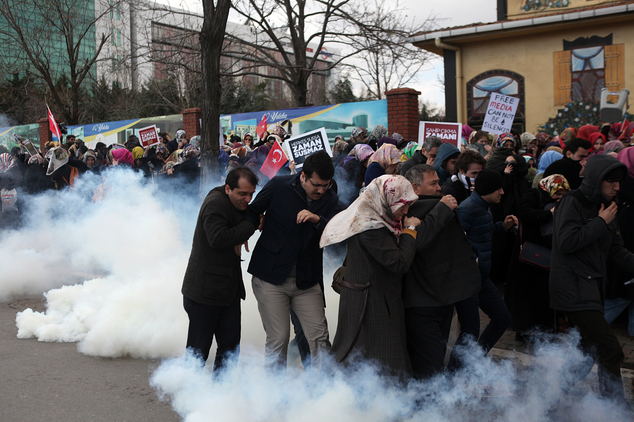People run as riot police use tear gas and water cannons to disperse people gathered in support outside the headquarters of Zaman newspaper in Istanbul, Saturday, March 5, 2016. The European Union is facing increasing pressure to speak out against the erosion of media freedom in Turkey following the takeover of the country's largest-circulation newspaper, but few expect it to take a bold stance toward Ankara while trying to assure its help in dealing with the migration crisis. Police used tear gas and water cannons for a second day running on Saturday to disperse hundreds of protesters who gathered outside the headquarters of Zaman newspaper  now surrounded by police fences. (AP Photo)