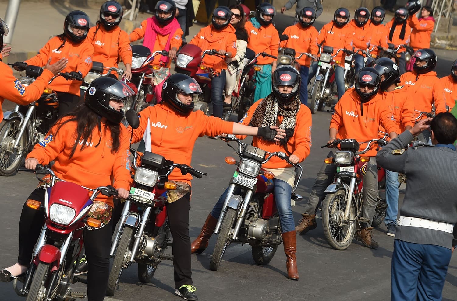 Women participants of Women on Wheels (WOW) wait on their motor-bikes prior to the start of a rally launching the Women on Wheels campaign in Lahore on January 10, 2016. AFP PHOTO / Arif ALI